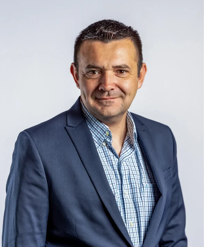 Professional headshot of a smiling man